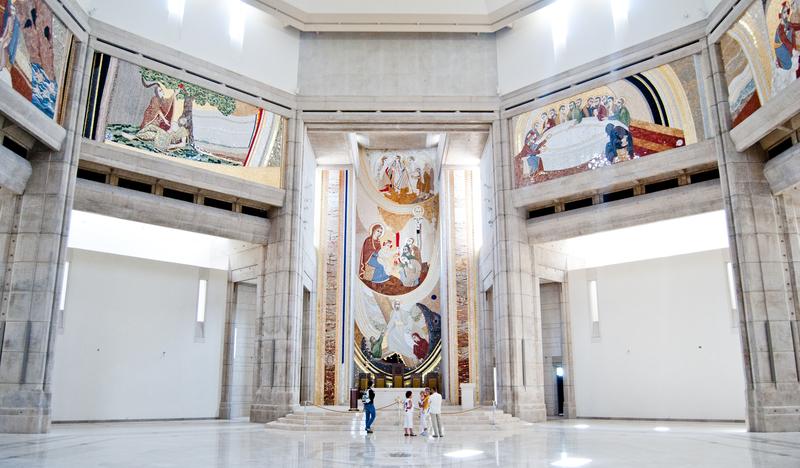 Monumentalne, jasne wnętrze sanktuarium świętego Jana Pawła, na ścianach kolorowe malowidła.
