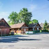 Drewniana zabudowa we wsi Mokrzyska, chaty stojące wzdłuż drogi.