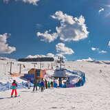 Grupa osób - narciarzy i snowboardzistów korzystających z usług stacji narciarskiej Master Ski w Tyliczu w zimowy słoneczny dzień.