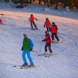 Grupa dzieci z instruktorem jazdy na nartach na stacji narciarskiej Wierchomla