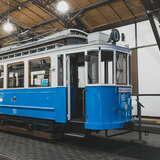 Widok na zabytkowy niebieski tramwaj wystawiony w Muzeum Inżynierii i Techniki w Krakowie.